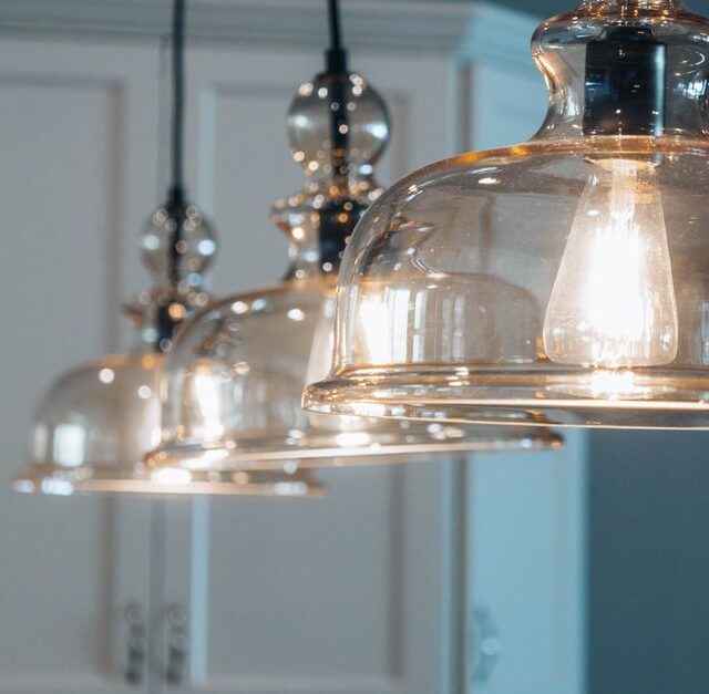 Suspension moderne élégante au-dessus d'un îlot de cuisine avec éclairage chaleureux.
