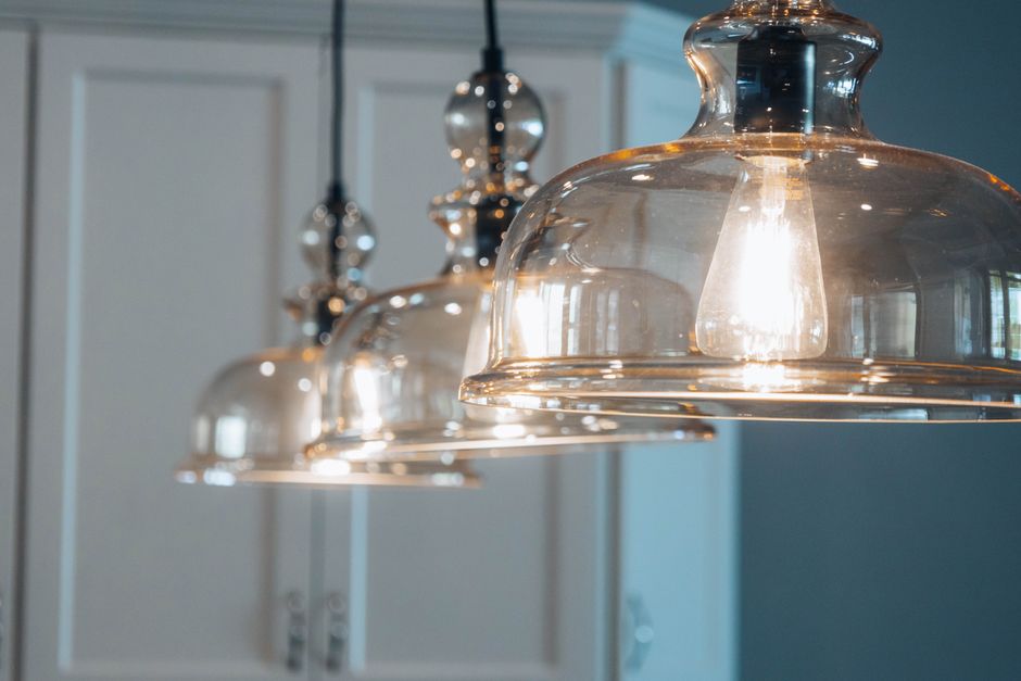 Suspension moderne élégante au-dessus d'un îlot de cuisine avec éclairage chaleureux.